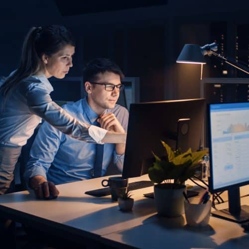 Two people working on computer in office